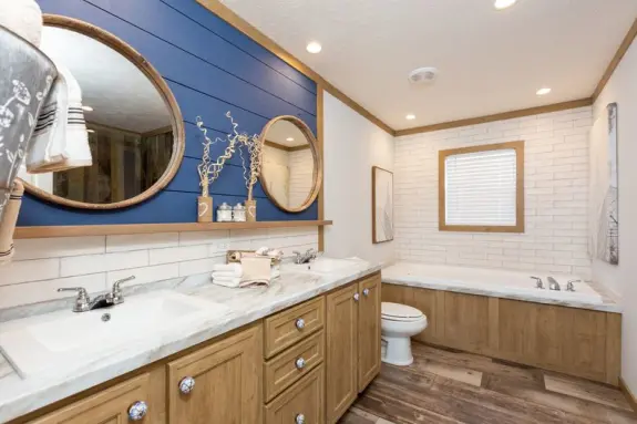 The [model name] features a primary bathroom with an accent wall and a soaker tub.
