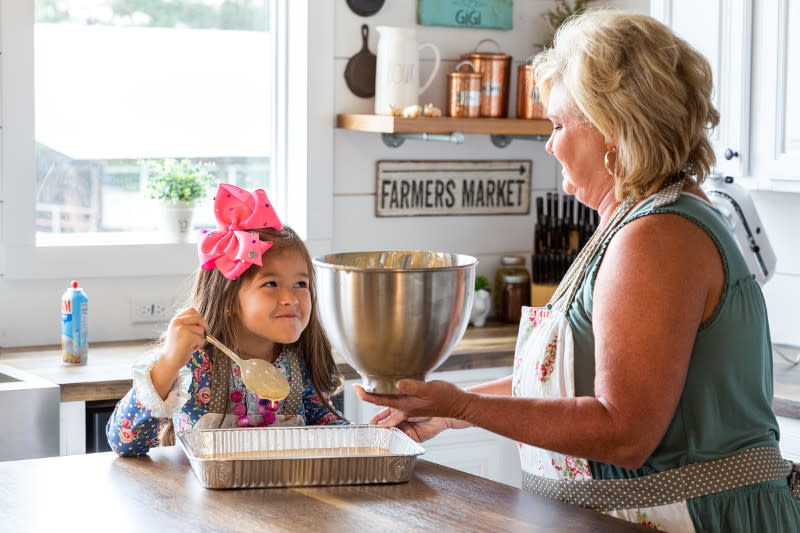 Woman and granddaughter backe inside a manufactured home kitchen decorated with farmhouse decor.