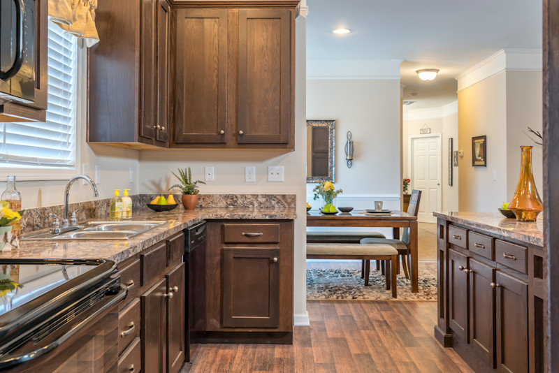 Modular home kitchen with oak stained cabinets and a large dining area.