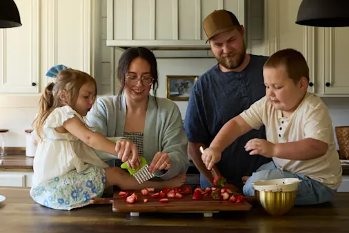 The Isaacks family cutting strawberries in their kitchen