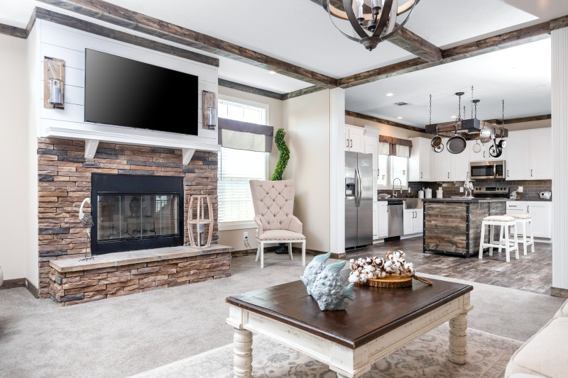 Interior of manufactured home living room with open floor plan and ceiling beams.