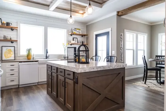 The barn door style kitchen island accent piece surrounded by the bright white cabinets in the 1434 Carolina "Southern Belle" makes this a farm girl's dream home with eat-in dining room nearby.