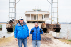 Norbert and Ted standing in front of their Clayton Homes on a barge at the dock
