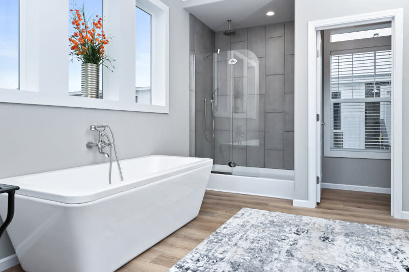 A primary bathroom suite in a manufactured home with a standing glass shower and a separate soaking tub.