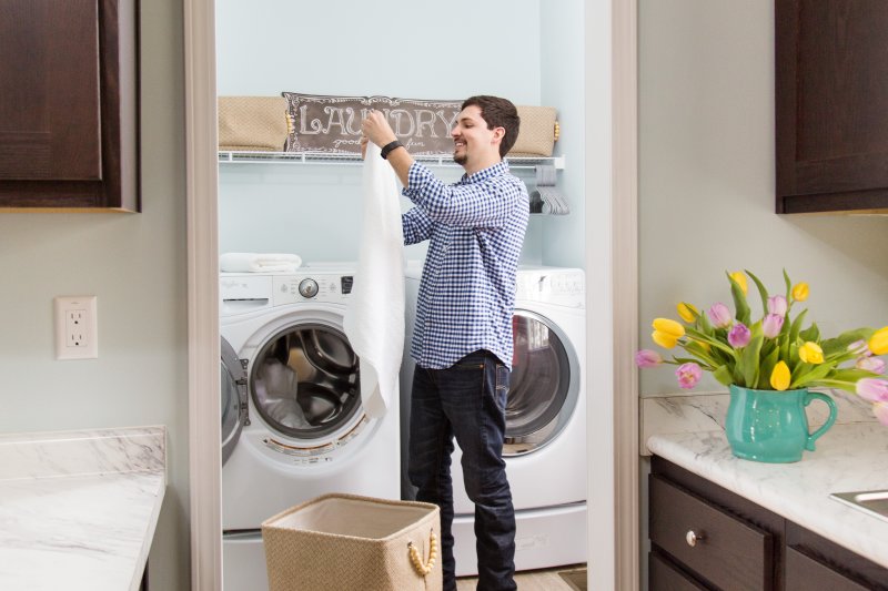 Man folding clothes in a the laundry room of a manufactured home