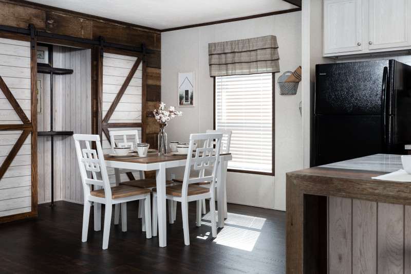 Dining room of the Stockton model, with dining room table set and sliding barn doors on the pantry.