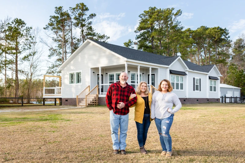 Family stands in front of their new farmhouse home built by Clayton Homes