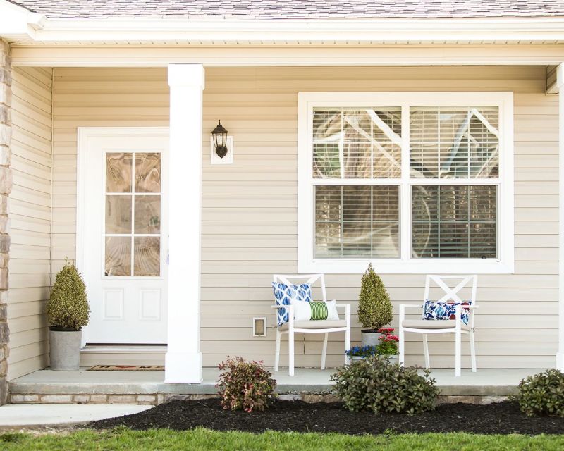 Manufactured home porch with white columns.