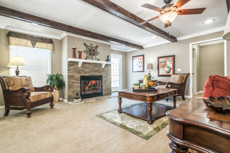 Roomy family room with a brick fireplace and plenty of natural lighting.