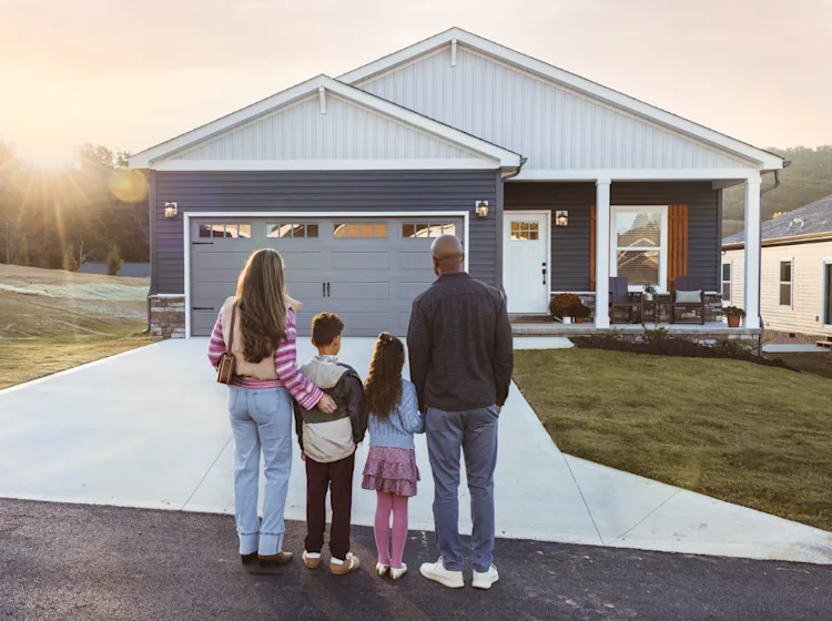 Family stands outside of their new construction CrossMod home.