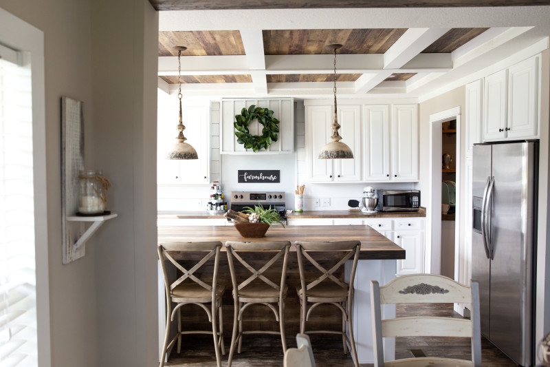 Interior of a manufactured home kitchen with stainless steel appliances and coffered ceilings.