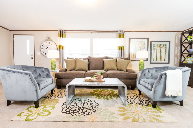Manufactured home living room with a large window and carpet floors.