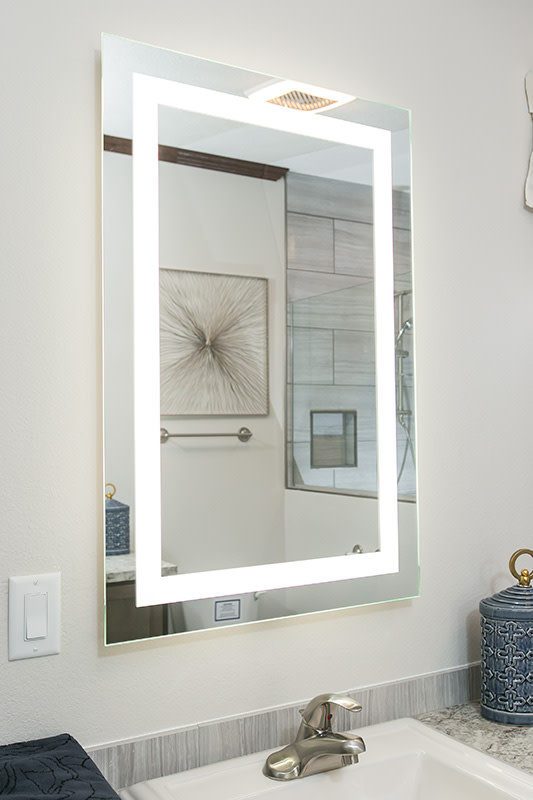 A backlit mirror in a manufactured home bathroom.