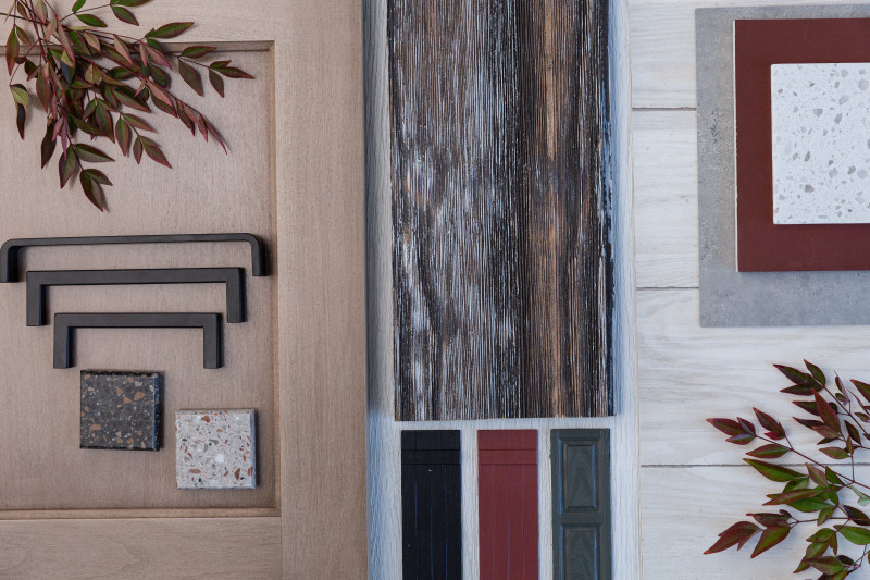 A flat lay of design trends like wood, travertine tile, cabinet pulls and branches