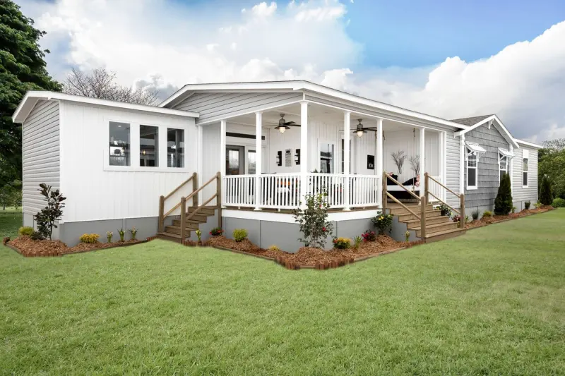 An exterior shot of a manufactured home featuring a large covered porch and two sets of stairs.