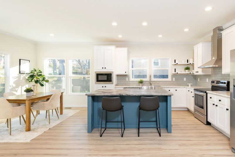 bright kitchen with white cabinets and a blue accent island