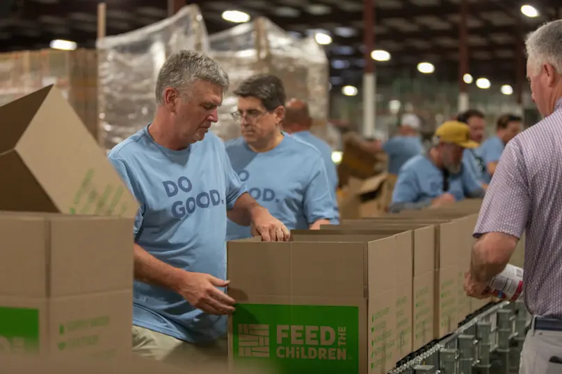 Clayton team members volunteers and build boxes to pack with food.