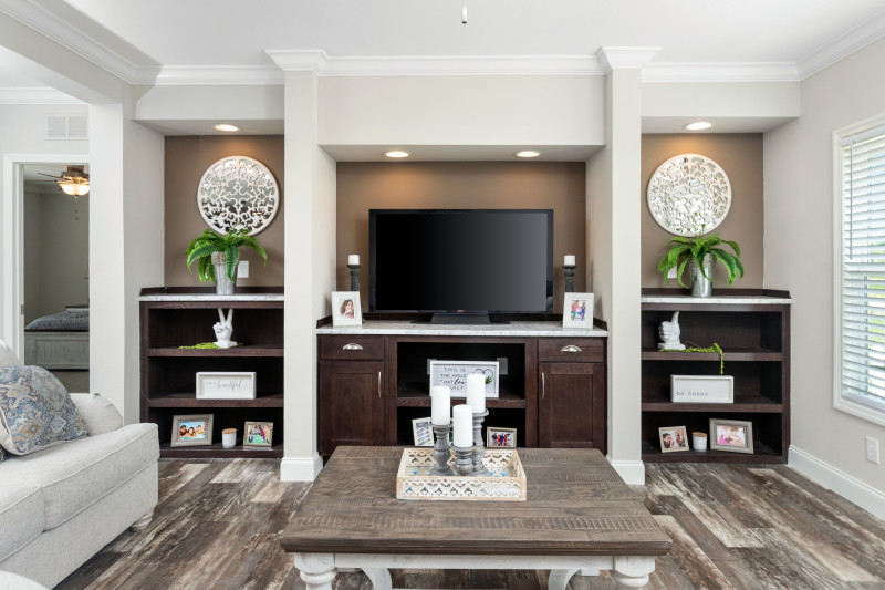 A built-in entertainment center with dark stained wood, cabinets and shelving. 