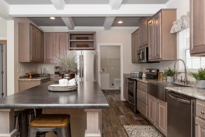 Manufactured home kitchen with a walk-in utility room and a large kitchen island.