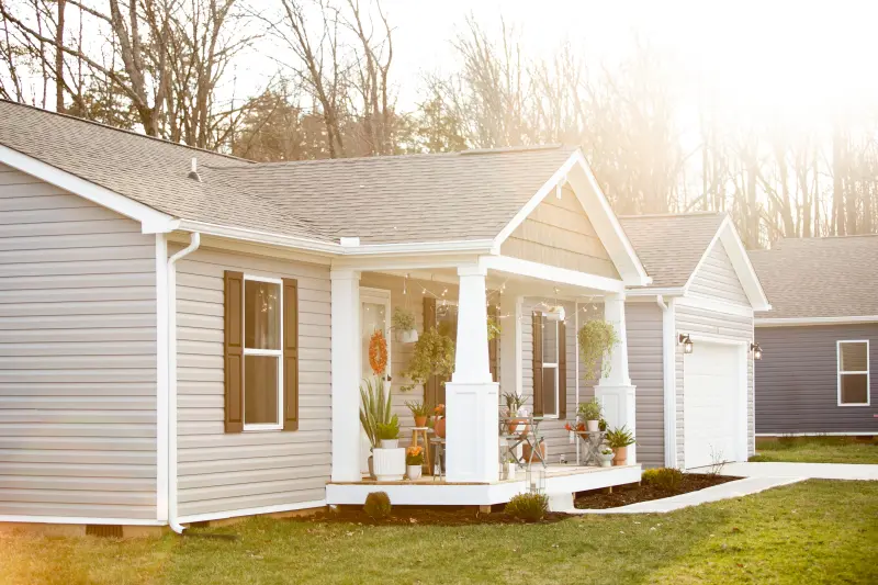 Exterior of a Manufactured home with a front porch and lawn.