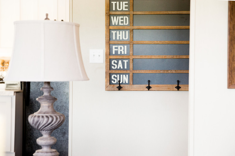 Manufactured home entryway with a chalk board calendar and hooks.
