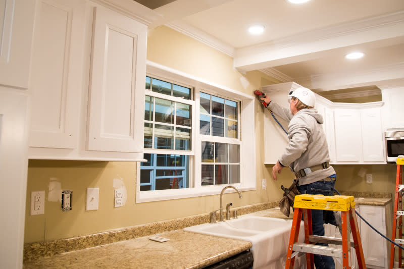 Team member works inside the kitchen of a manufactured home being constructed in a home building facility.