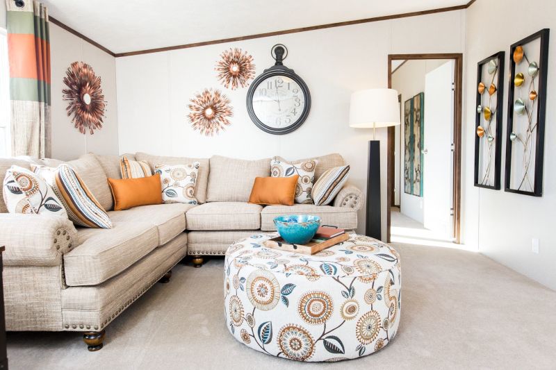 View is of a living room with orange, white, and blue décor and accents.