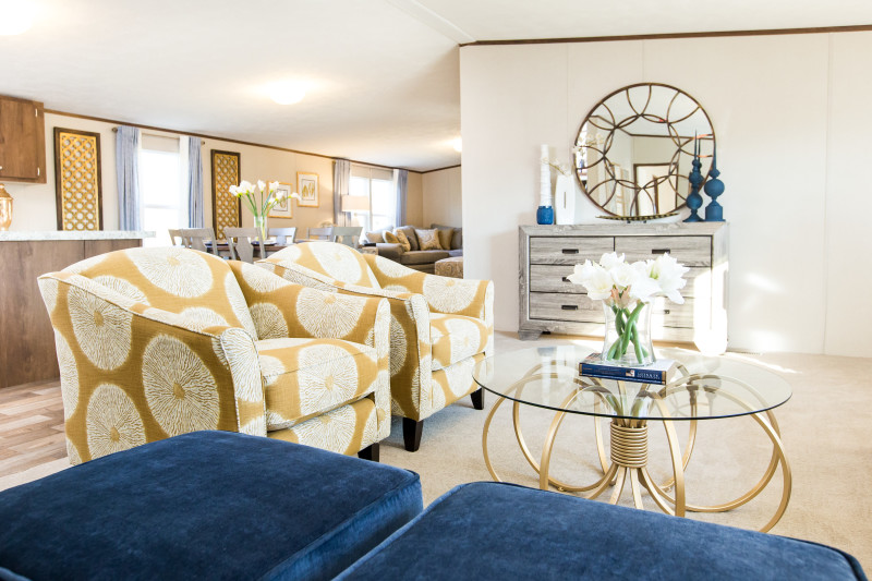 Modern living room with yellow accent chairs and touches of blue throughout the room.