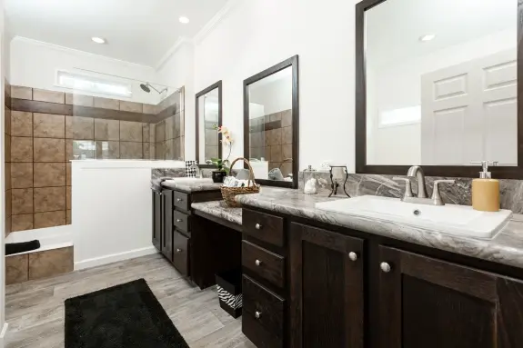 The [model name] features a built-in vanity between two sinks and a walk-in shower.
