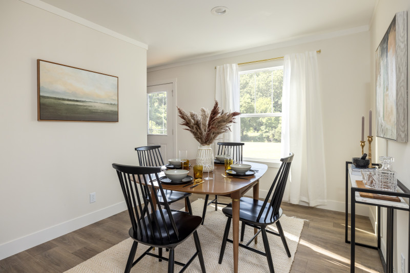 Flex space of a Tempo manufactured home turned into a dining room, with 4 chairs, a table and a bar cart.