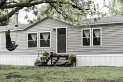 grey prefabricated home exterior with black door