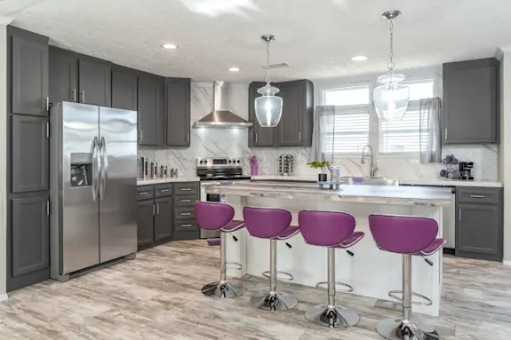 The Stella has elegant features like marble-style continuous countertop backsplash and glass pendant lights.