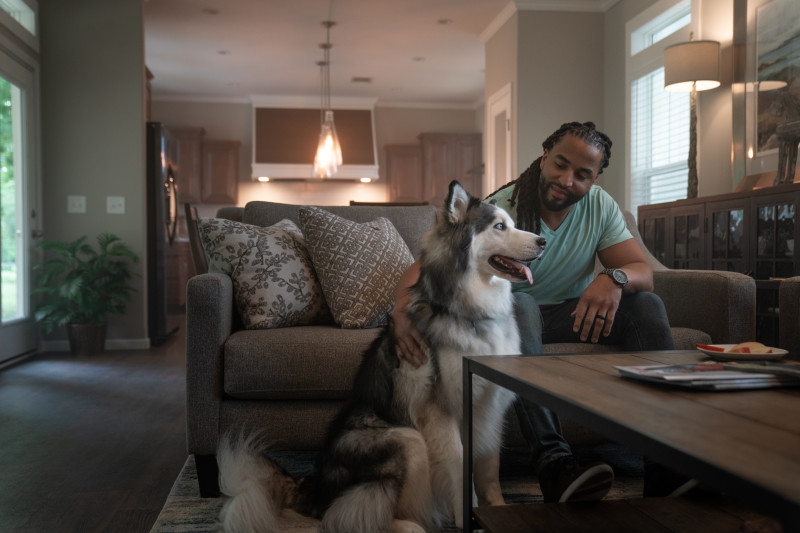A man and dog sitting in the living room of The Laney Clayton Built Home
