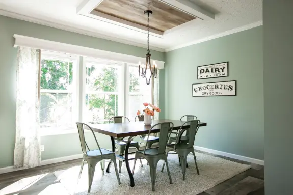The pastel green wall paint in the Country Aire dining room makes this home feel modern while staying true to it's down home roots with farmhouse shiplap ceiling accents and more!