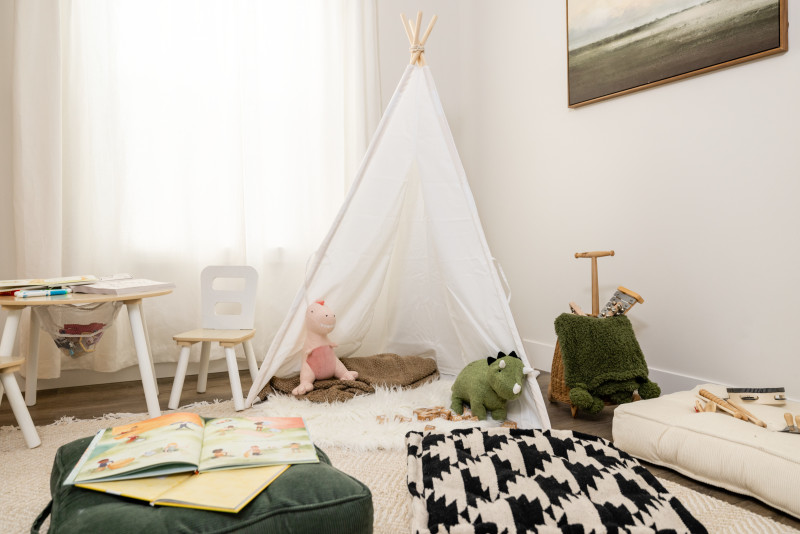 A flex room in a manufactured home that has toys, children’s books and a teepee
