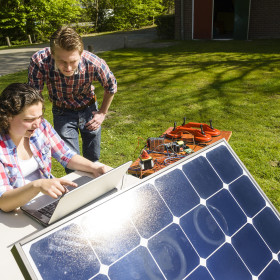 Twee studenten die een zonnepaneel aan het testen zijn. 