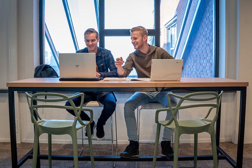 Twee studenten die aan de slag gaan met SharePoint. 