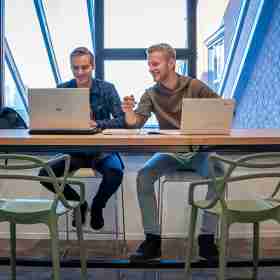 Twee studenten die aan de slag gaan met SharePoint. 