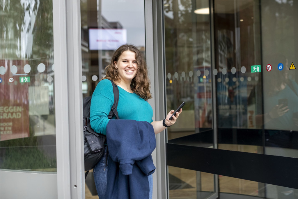 Studente kijkt op haar mobiel naar welzijnsmonitor app