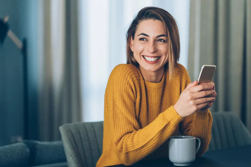 Stockfoto Junge Frau mit Kaffee am Tisch