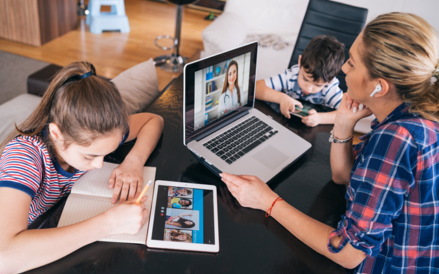 Dreiköpfige Familie, die Tablet, Laptop und Smartphone zeitgleich nutzt