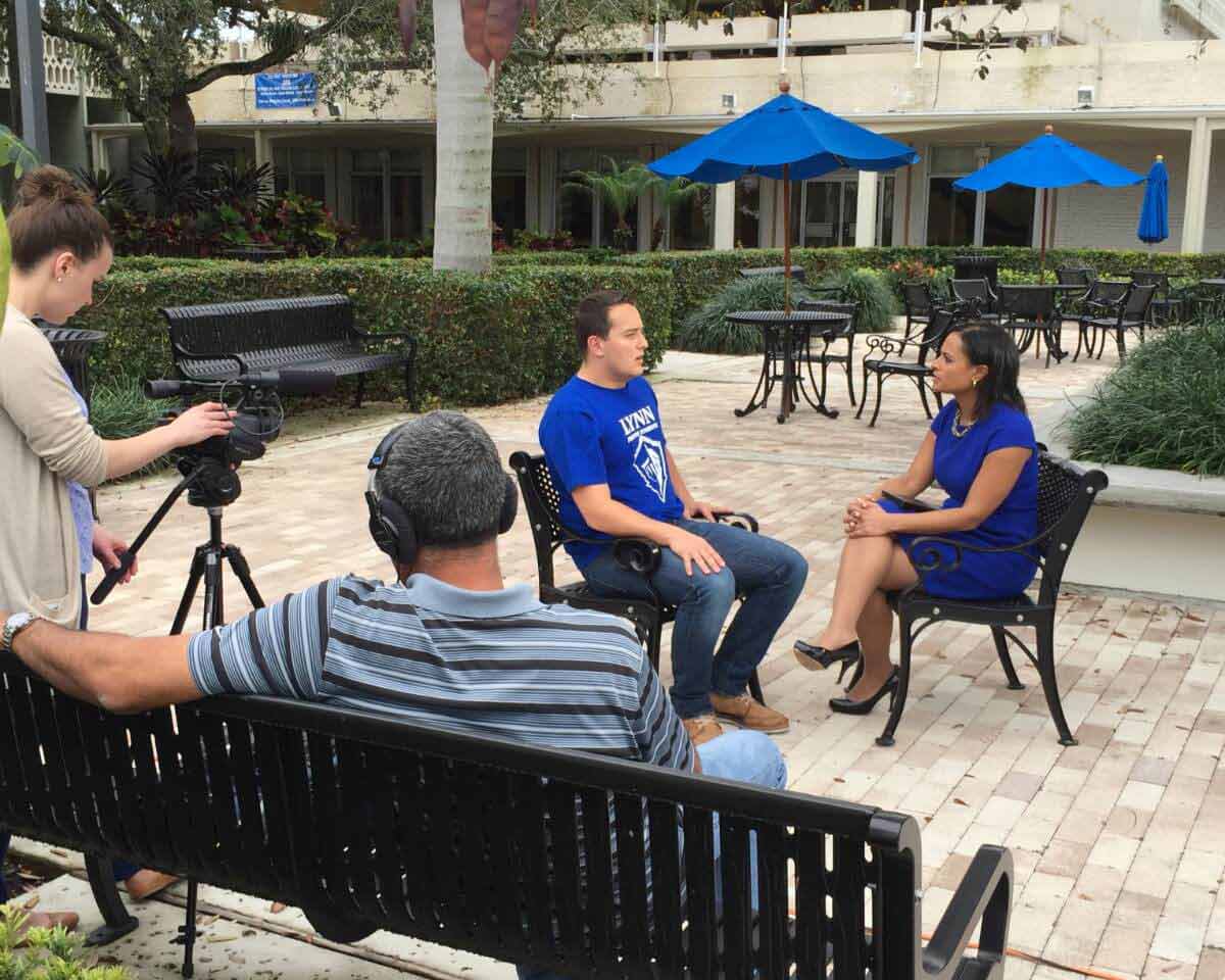 Communications and media students filming an interview in a garden outdoors