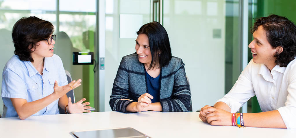 Lynn students speaking with an instructor in a meeting room