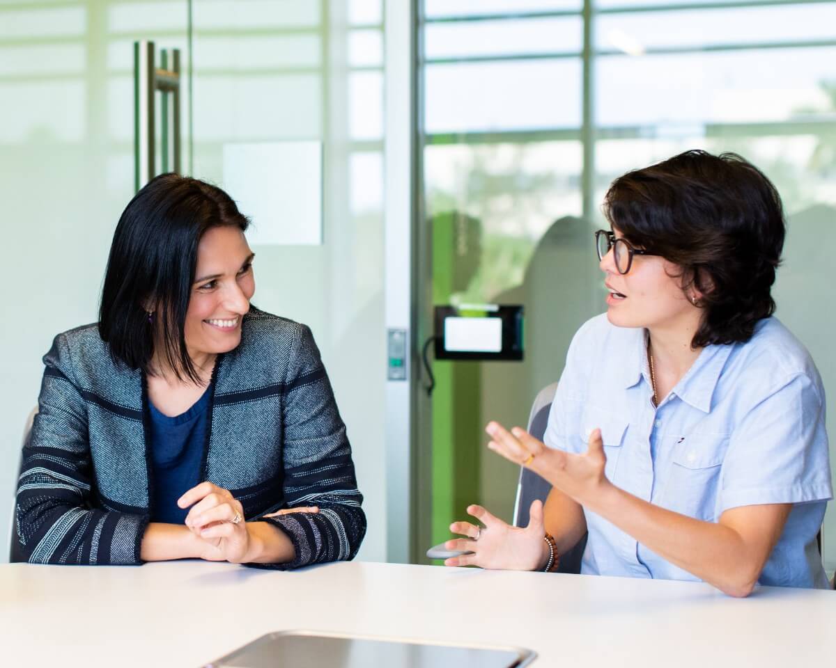 Lynn student speaking with an instructor in a meeting room