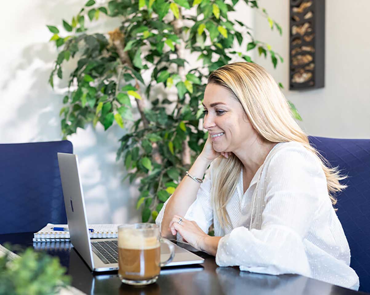 Student looking at a laptop in a home office