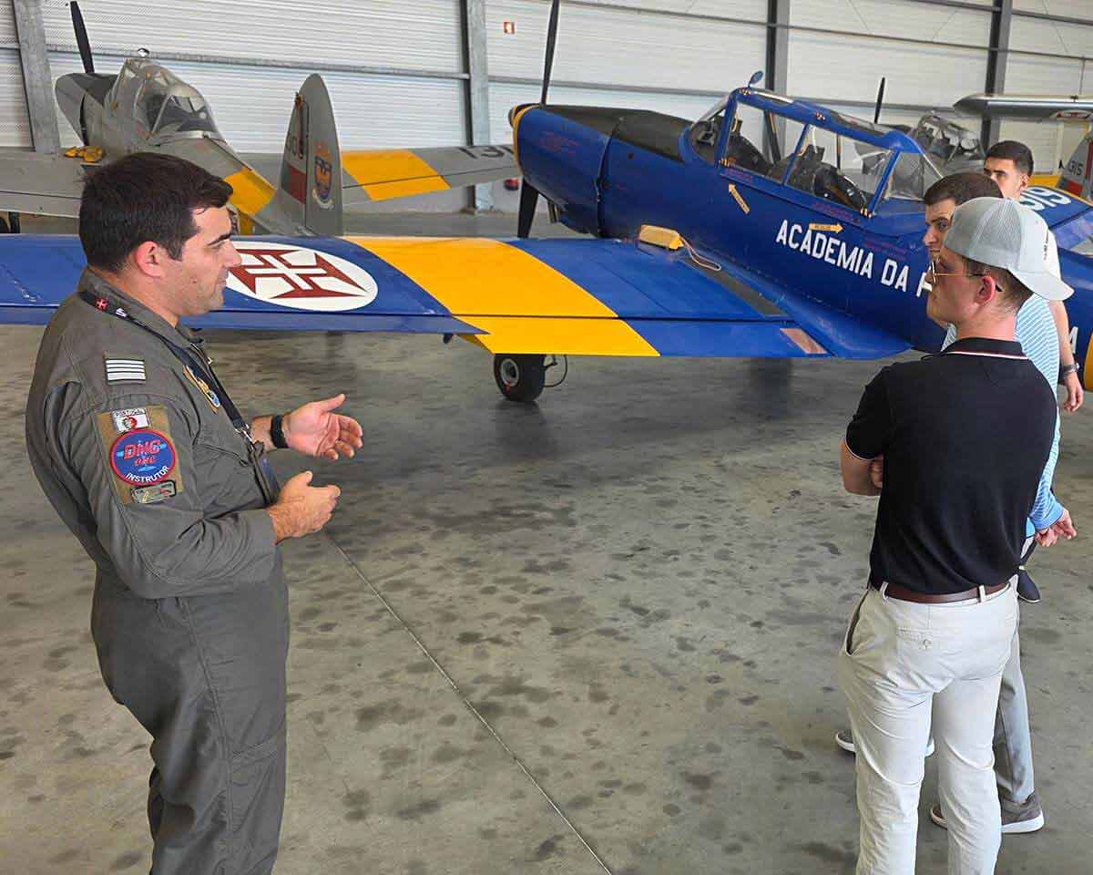 Lynn aviation instructor addressing students next to an airplane in a hangar