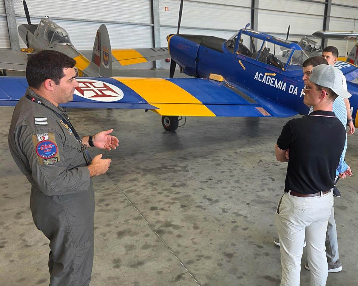 Lynn aviation instructor addressing students next to an airplane in a hangar