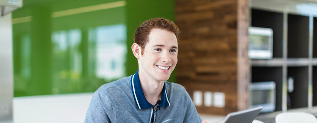Lynn student working on a laptop in a break room