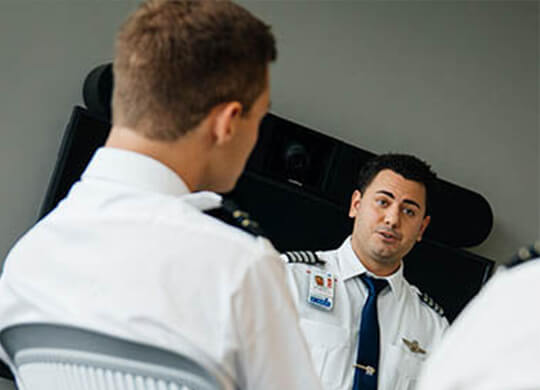 Lynn aviation students in uniform having a meeting