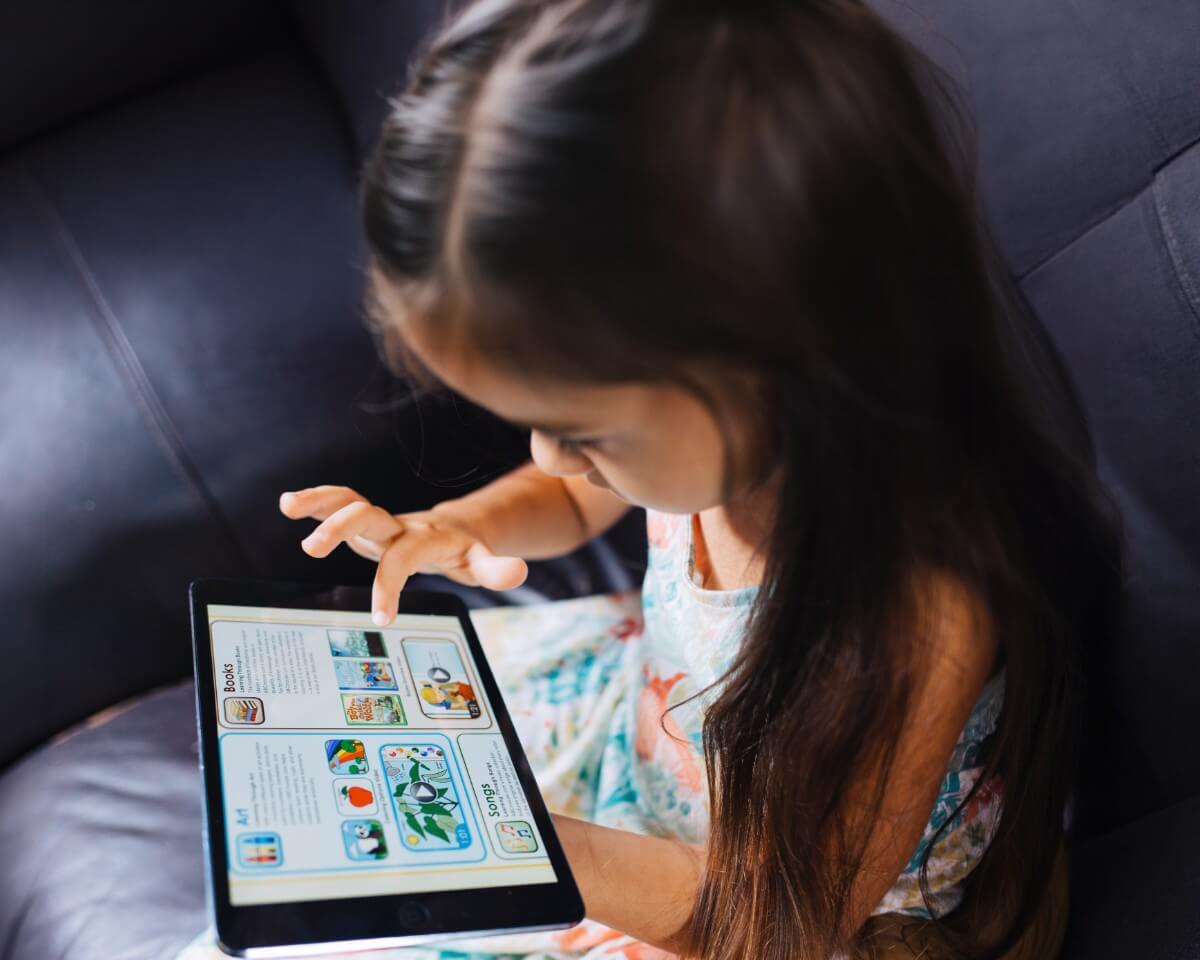 Young girl interacting with an educational app on a tablet